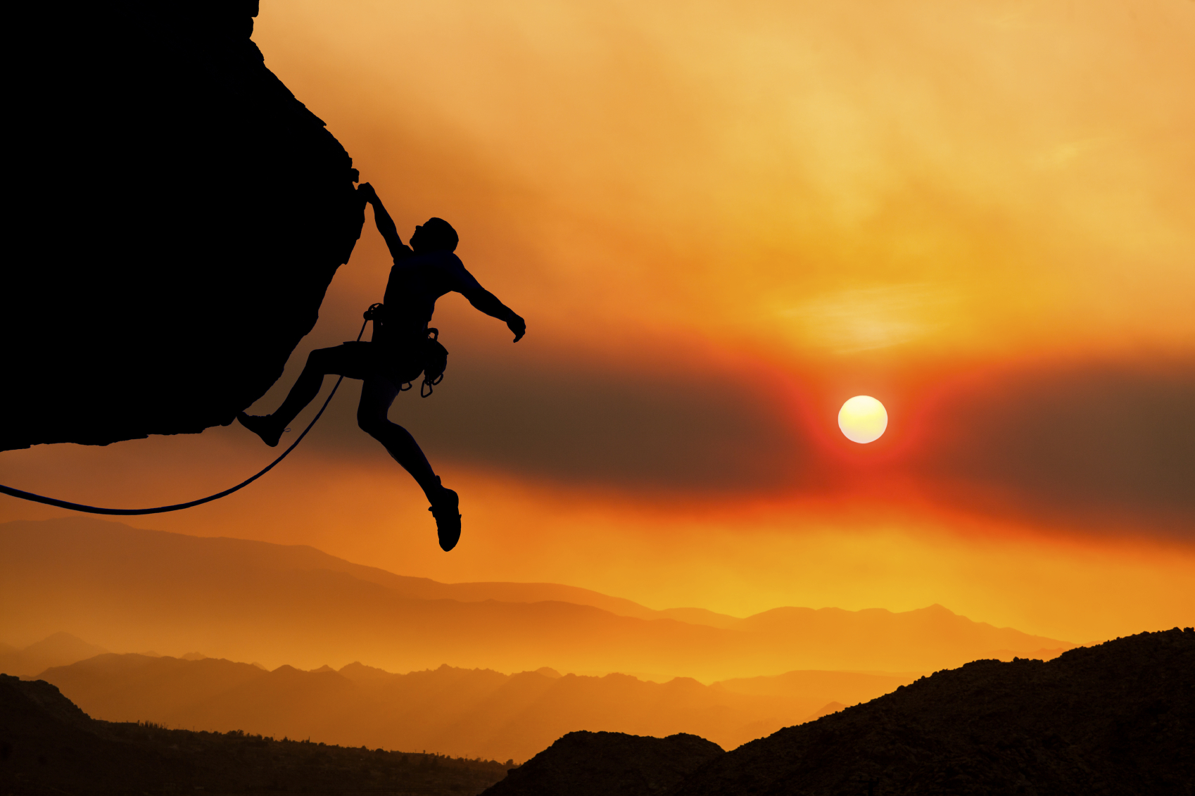 Silhouette of a rock climber at sunset